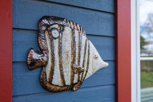 eine Fischdekoration an der Seite eines blauen Hauses in der Unterkunft 60 m² Wohnlichkeit für Ihre Auszeit an der Ostsee in Bansin