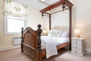 1 dormitorio con cama con dosel y ventana en Charming On Charles, en Launceston