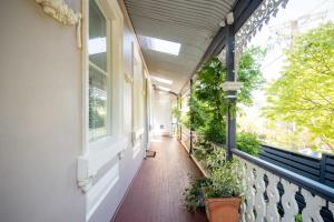 un porche vacío de una casa con ventanas y plantas en Charming On Charles, en Launceston