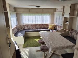 una pequeña sala de estar con mesa y sofá en Domki holenderskie HEL en Hel