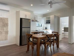 a kitchen and dining room with a wooden table and chairs at BIG4 Tweed Billabong Holiday Park in Tweed Heads