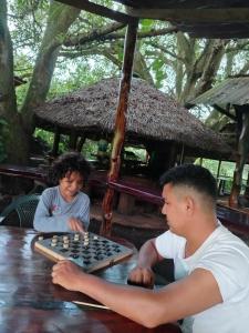 a couple of people playing a game of chess at Campo Duro Ecolodge in Puerto Villamil