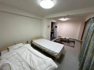 um quarto com 2 camas e um frigorífico em コンドミニアム定山渓307 em Jozankei