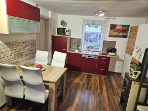 een keuken met een houten tafel en witte stoelen bij Apartments Karin in Bled