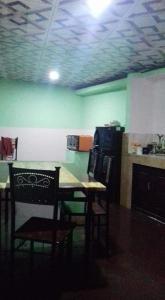 eine Küche mit einem Tisch und Stühlen sowie grünen Wänden in der Unterkunft Kuchi Villa in Kalutara