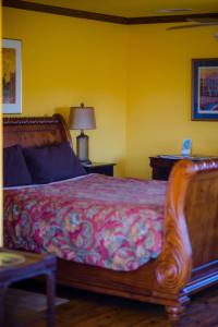 een slaapkamer met een bed en een tafel met een lamp bij Sequoia View Vineyard in Sanger