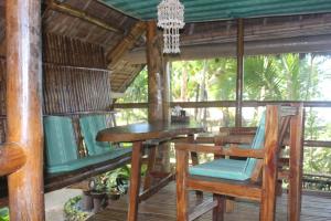 a porch with a table and chairs on a deck at Driftwood Village Resort in Sipalay