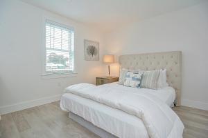 a white bedroom with a large bed and a window at Harbourtown Suites, Unit 213 in Plymouth