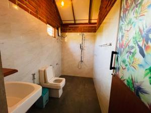 y baño con aseo, lavabo y ducha. en Sungreen Cottage Sigiriya en Sigiriya