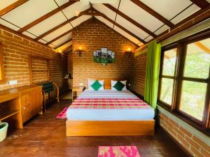 Sungreen Cottage Sigiriya في سيجيريا: غرفة نوم بسرير كبير في جدار من الطوب