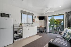 Tasman Holiday Parks - Miranda في ميراندا: مطبخ وغرفة معيشة مع أريكة وطاولة
