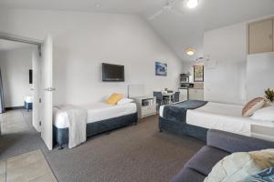 um quarto de hotel com duas camas e um sofá em Tasman Holiday Parks - Miranda em Miranda