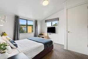 a bedroom with a large bed and a television at Tasman Holiday Parks - Miranda in Miranda