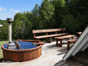 una terraza de madera con bañera de hidromasaje y banco en La Merced en Villarrica