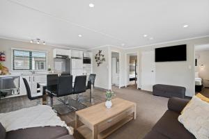 ein Wohnzimmer mit einem Sofa und einem Tisch sowie eine Küche in der Unterkunft Tasman Holiday Parks - Miranda in Miranda