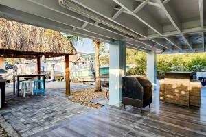 a patio with a table and a thatch roof at Hammock Haven in Key Largo