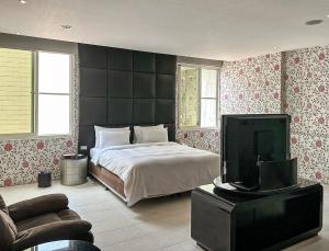 a bedroom with a bed and a flat screen tv at All-Ur Boutique Motel-Jhu Shan Branch in Zhushan