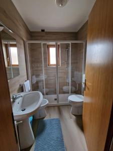 uma casa de banho com um lavatório, um WC e um chuveiro em Alloggio Turistico Bufera em Roana