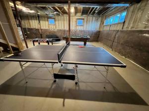 una mesa de ping pong en una habitación con una pelota de ping pong en Niagara's entertainment house en Thorold