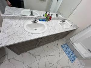 baño con 2 lavabos y encimera de mármol en Niagara's entertainment house en Thorold