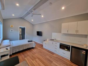 a bedroom with a bed and a kitchen with a tv at Gulgong Tourist Park in Gulgong