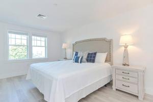 a white bedroom with a large white bed and two lamps at Harbourtown Suites, Unit 211 in Plymouth