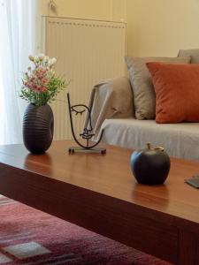 a coffee table with a vase of flowers and an apple on it at The fir trees house - Το σπίτι με τα έλατα in Litochoro