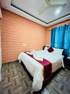 a bedroom with two beds and a brick wall at The Stream View Villas Wayanad in Vythiri