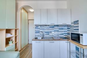 a kitchen with white cabinets and a sink at La Finestra Sul Mare 200mt From Sea - Happy Rentals in San Bartolomeo al Mare