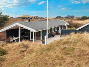 a house with a metal roof on top of a hill at Holiday home Blokhus LXX in Blokhus