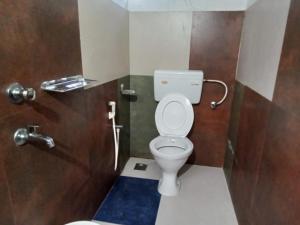 a bathroom with a white toilet in a stall at ORMAYIDAM RESIDENCY in Trivandrum