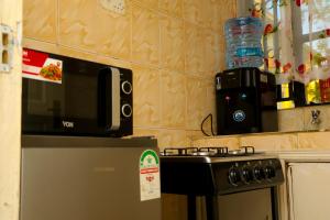 um micro-ondas sentado em cima de um fogão numa cozinha em Skybeach apartment em Kisumu