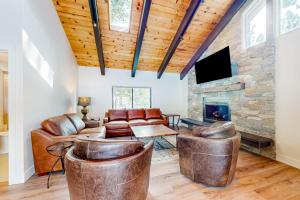 sala de estar con muebles de cuero y chimenea de piedra. en Piney Way, en Incline Village
