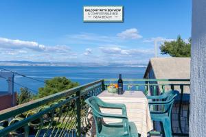 einen Tisch auf dem Balkon mit einer Flasche Wein in der Unterkunft Apartments Sandra in Stomorska