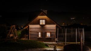 a small wooden house with windows at night at Jaworowa Osada in Brenna +81 photos