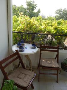una mesa blanca y sillas en un balcón con ventana en Helios Rhodos Apartments 1 en Koskinou