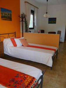2 camas en una habitación con paredes de color naranja en Helios Rhodos Apartments 1 en Koskinou