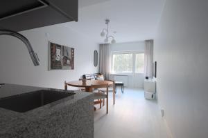 een keuken en eetkamer met witte muren en een tafel bij Urban Oasis - Two Bedrooms - Balcony - Nearby Metro in Helsinki