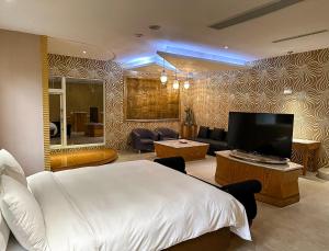 ein Hotelzimmer mit einem Bett und einem TV in der Unterkunft All-Ur Boutique Motel-Jhu Shan Branch in Zhushan