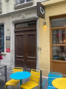 Un grupo de mesas y sillas frente a un edificio. en Comme une chambre d’hôtel au cœur de Lyon, en Lyon