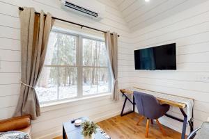 a room with a desk and a tv and a window at Bald Mountain Tiny House in Bucksport