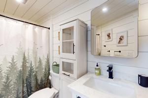 La salle de bains est pourvue de toilettes, d'un lavabo et d'un miroir. dans l'établissement Bald Mountain Tiny House, à Bucksport