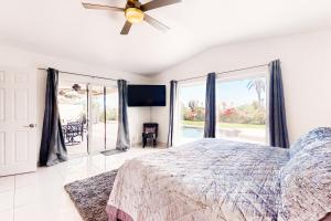 パームデザートにあるPalm Desert Doveのベッドと天井扇風機のある寝室 +27枚の写真