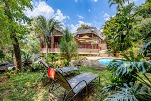 a yard with chairs and a house with a pool at Woodlands Guest House in Hazyview