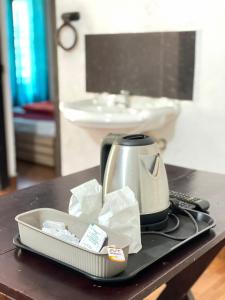 a tea kettle on a tray on a table at The Stream View Villas Wayanad in Vythiri