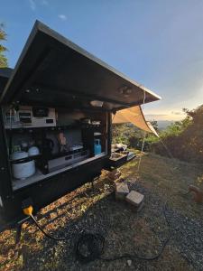 San Mateo的住宿－UCM Adventure Park，一辆黑色食物车,在山坡上搭帐篷