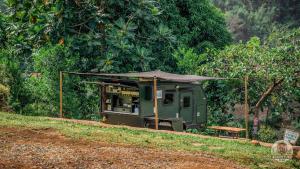 a green food cart with a tent on a hill at UCM Adventure Park in San Mateo
