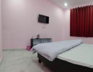 a bedroom with a bed and a flat screen tv at Hotel Royal Grand in Dehradun