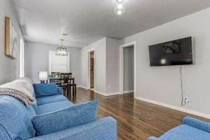 sala de estar con sofá azul y TV en Oklahoma Oasis House, en Del City