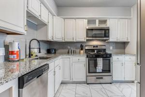 a kitchen with white cabinets and stainless steel appliances at Oklahoma Oasis House in Del City